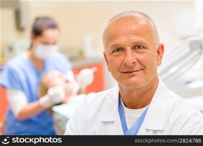 Portrait of mature dentist surgeon posing at office