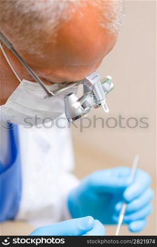 Portrait of mature dentist surgeon with special glasses