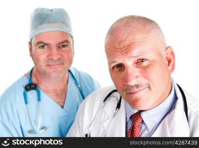 Portrait of mature doctor and younger surgeon isolated on white.