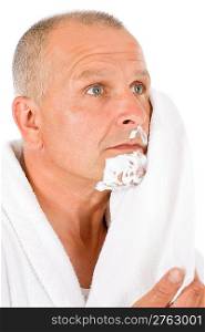 Portrait of mature handsome man wiping shaving foam with towel