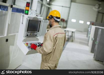 Portrait of mature man operating machine units in modern wood factory standing by control panel