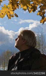 Portrait of mature man with grey hair in autumn day.