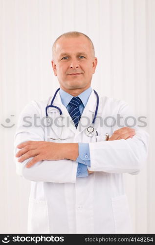 Portrait of mature professional doctor male with stethoscope crossed arms