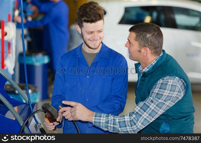 portrait of mechanic and apprentice talking