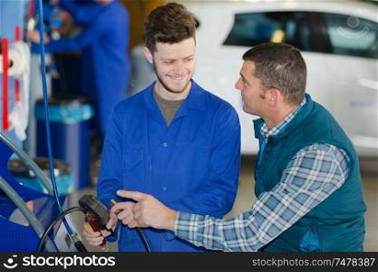 portrait of mechanic and apprentice talking