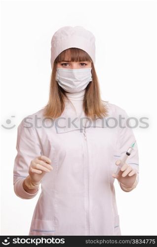 Portrait of medical worker in a white coat, hat, gloves and a mask, with a syringe and vial in hands