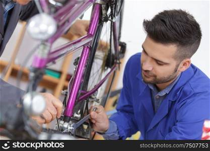 portrait of men assembling a bicycle