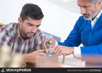 portrait of men fixing something