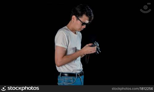 Portrait of men holding a DSLR looking camera on dark studio background , asian