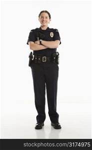 Portrait of mid adult Caucasian female law enforcement officer standing with arms crossed looking at viewer smiling.