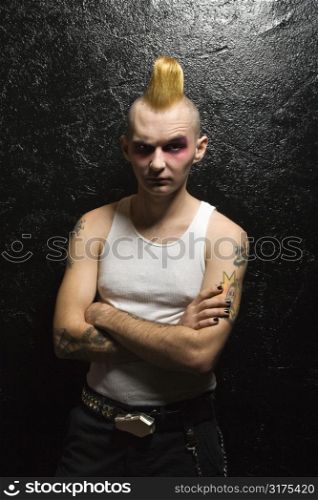 Portrait of mid-adult Caucasian male punk with arms crossed.