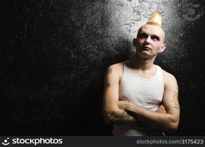 Portrait of mid-adult Caucasian male punk with crossed arms.