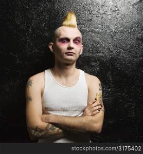 Portrait of mid-adult Caucasian male punk with his arms crossed.