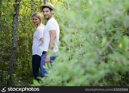 Portrait of mid adult couple walking through marshland