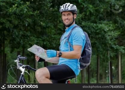portrait of mid-adult male cyclist looking at map