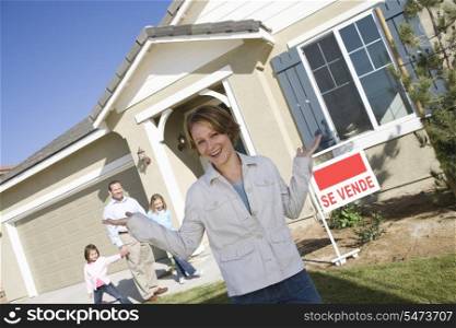 Portrait of mid-adult woman in front of new house