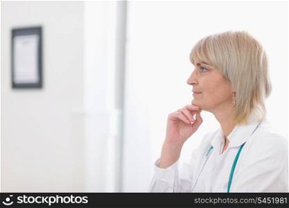 Portrait of middle age doctor woman looking on copy space
