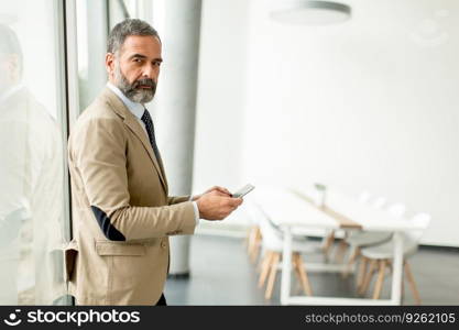 Portrait of middle aged  businessman with tablet in office