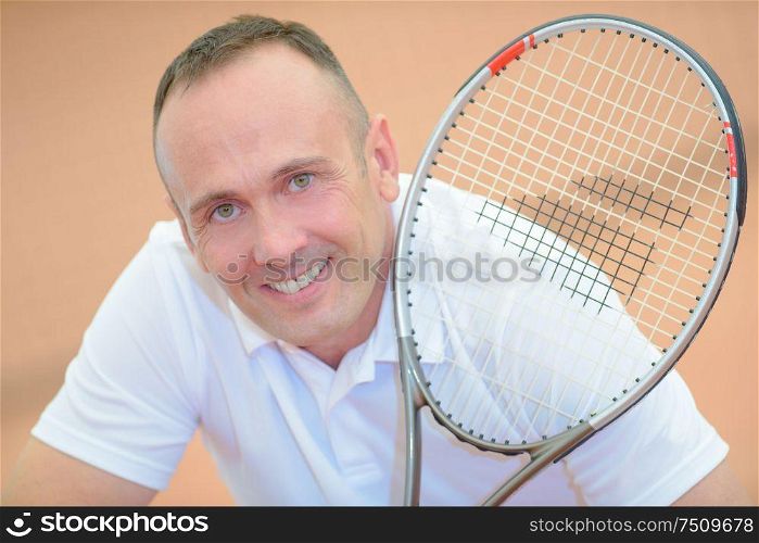 Portrait of middle aged man holding tennis racket