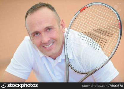 Portrait of middle aged man holding tennis racket