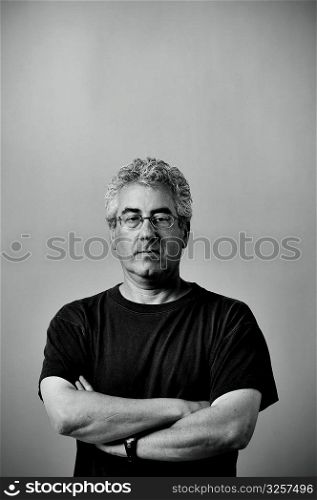 Portrait of middle aged serious man with arms folded.