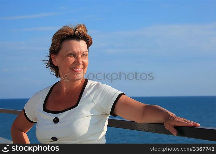 portrait of middleaged woman on balcony over sea