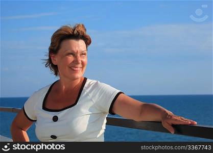 portrait of middleaged woman on balcony over sea