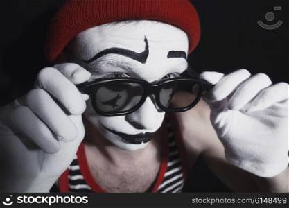 Portrait of mime wearing red hat and eyeglasses