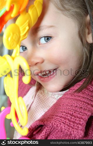 portrait of mischievous little girl posing with toy