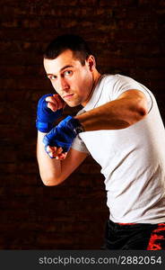 portrait of mma fighter in boxing pose against brick wall