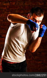 portrait of mma fighter in boxing pose against brick wall