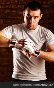portrait of mma fighter in boxing pose against brick wall
