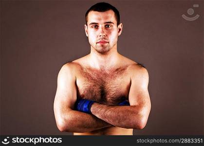 portrait of mma fighter with hands folded on gray background