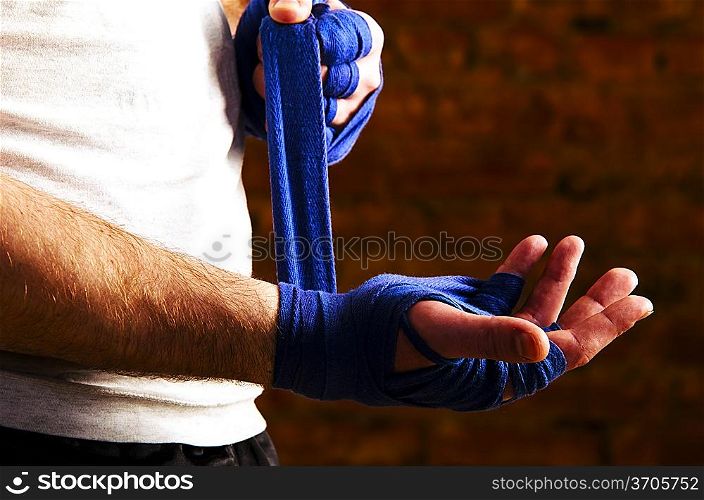 portrait of mma fighteris applying bondage tape on hands
