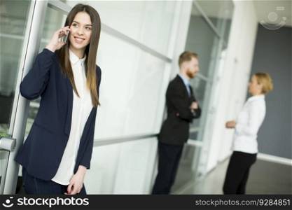 Portrait of modern businesswoman with speaking on the phone in working environment