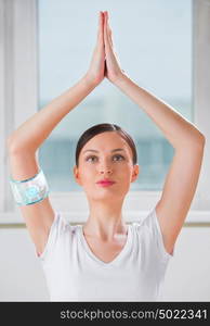 Portrait of modern healthy yoga woman wearing smart watch device with touchscreen