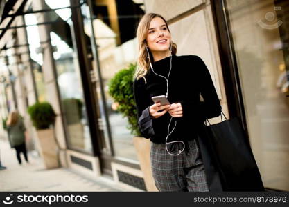 Portrait of modern young shopaholic woman on street