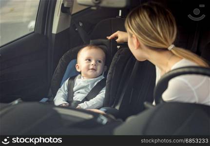 Portrait of mother and baby boy sitting in car on front seats