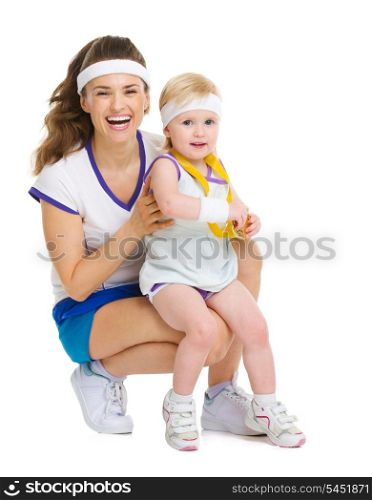 Portrait of mother and baby in tennis clothes with medal