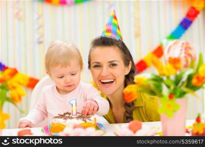 Portrait of mother and baby with birthday cake