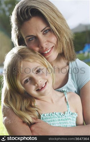 Portrait of mother and daughter (5-6) hugging and smiling