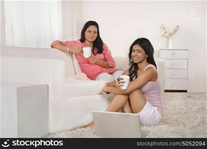 Portrait of mother and daughter having tea