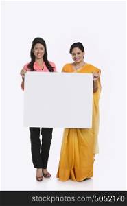 Portrait of mother and daughter holding white board