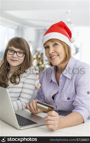 Portrait of mother and daughter shopping online during Christmas