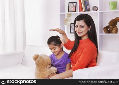 Portrait of mother and daughter with stuffed toy