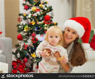 Portrait of mother and eat smeared baby near Christmas tree