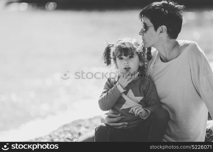 Portrait of mother and her little daughter having fun on the beach