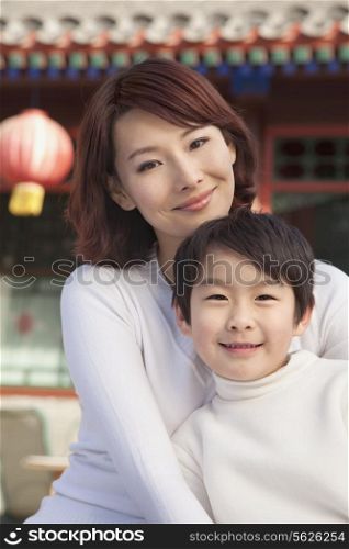 Portrait of mother and son outside traditional Chinese building
