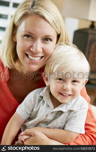 Portrait Of Mother And Son Sitting On Sofa At Home