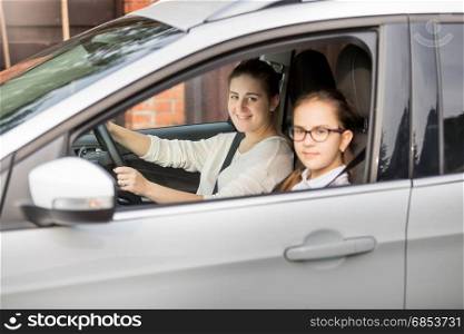Portrait of mother and two daughters riding in car